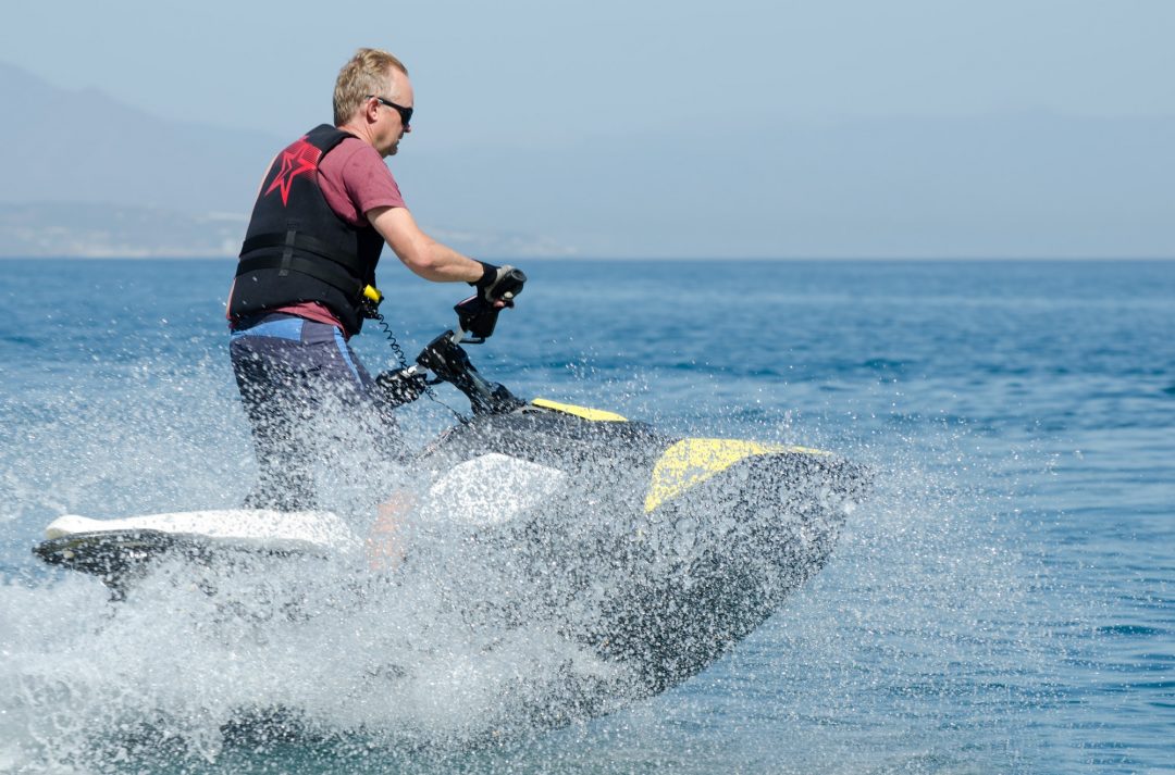 Man on jet ski surrounded by sea spray